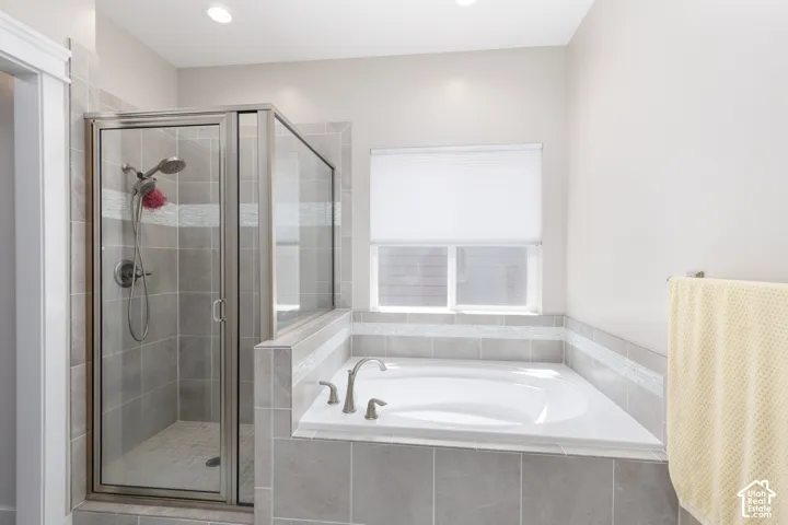 Walk-in shower with clear glass enclosure and tile surround