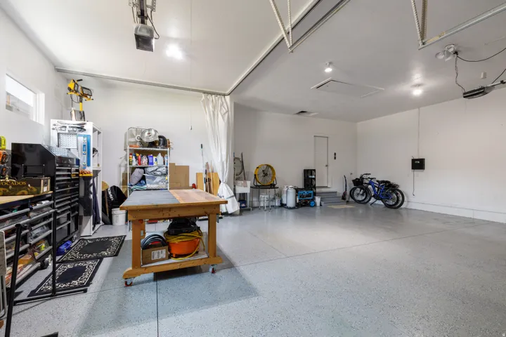 Attached garage with an epoxy floor, white walls, recessed lighting, and a window