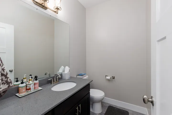 Built-in vanity with a gray countertop, undermount sink, and brushed nickel faucet