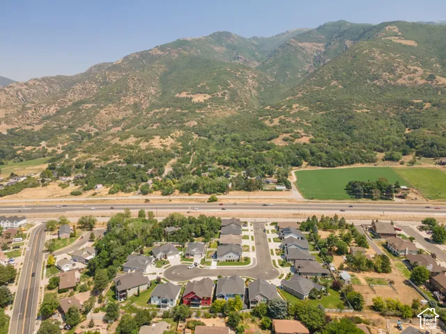 Aerial perspective featuring a residential cul-de-sac, multiple single-family homes, and a prominent mountain backdrop