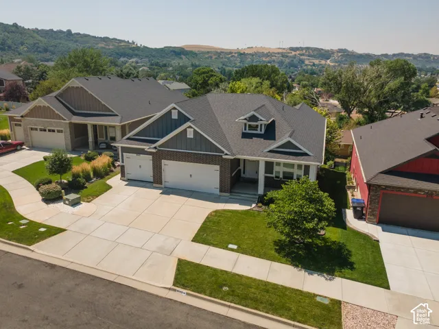 Contemporary exterior with brick and siding accents, prominent two-car garage, manicured front lawn, and mature landscaping