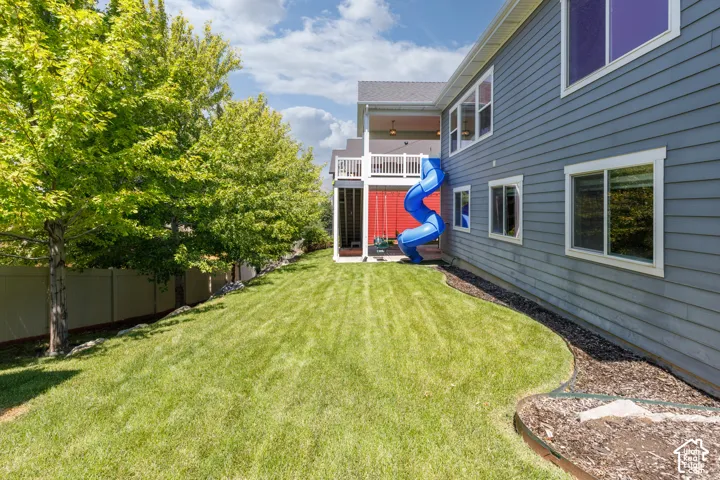 Expansive lawn area with mature trees and a privacy fence