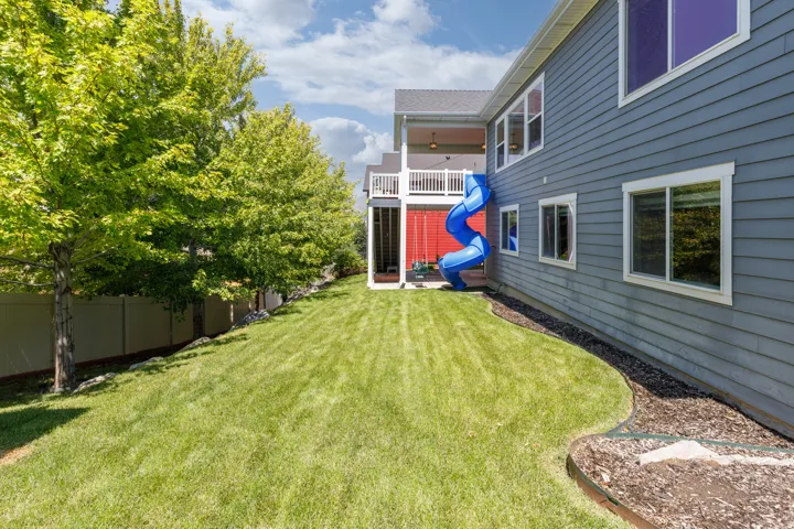 Expansive lawn area with mature trees and a privacy fence
