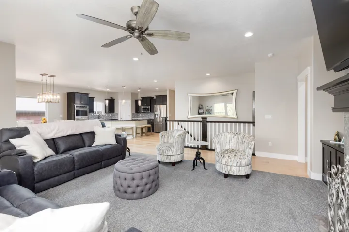 Open concept living space with recessed lighting, wood-finish flooring, and a fireplace with decorative screen