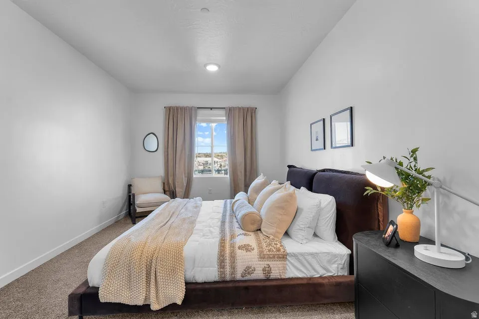 Carpeted flooring with a window offering natural light, complemented by an overhead light fixture