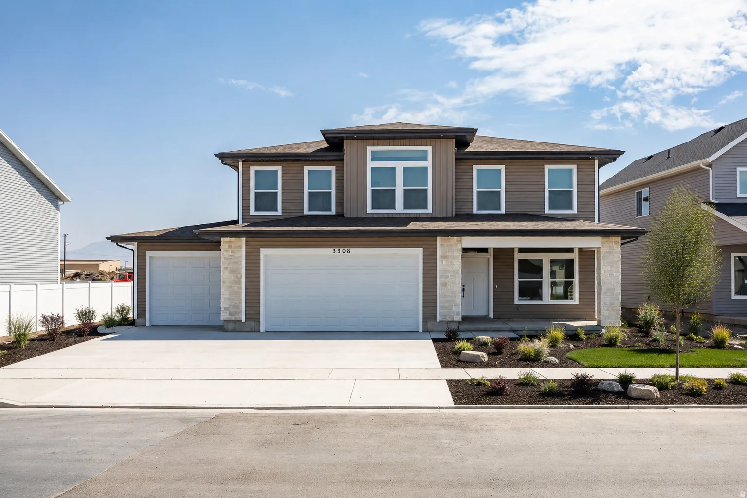 Two-story residence featuring a brown siding exterior, stone accents, and a three-car garage