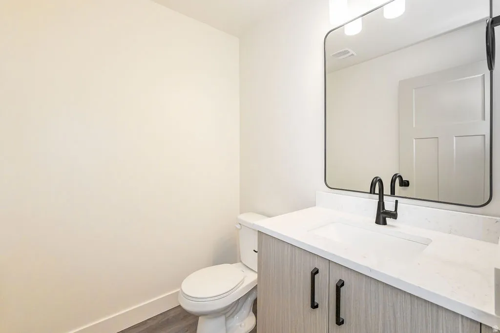 Vanity with stone countertop, integrated sink, and matte black hardware