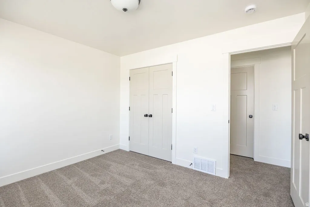 Neutral-toned carpet flooring, white walls, and white trim throughout