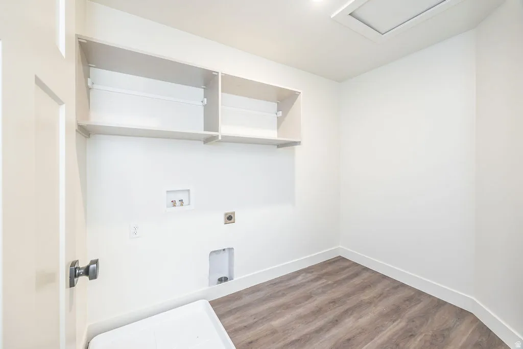 White paneled door with dark hardware, wood-finish flooring, built-in shelving, recessed ceiling light, and access panel