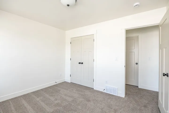 Neutral-toned carpet flooring, white walls, and white trim throughout