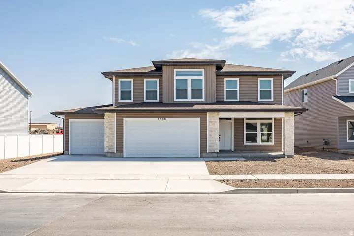 Contemporary exterior with brown siding, a two-car garage, and stone accents