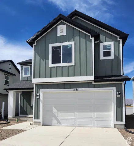 Two-story exterior with board and batten siding, white trim, and a prominent two-car garage