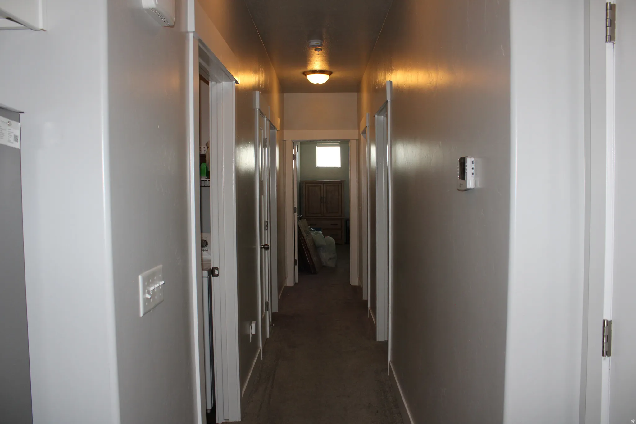 Hallway with light-colored walls and overhead lighting