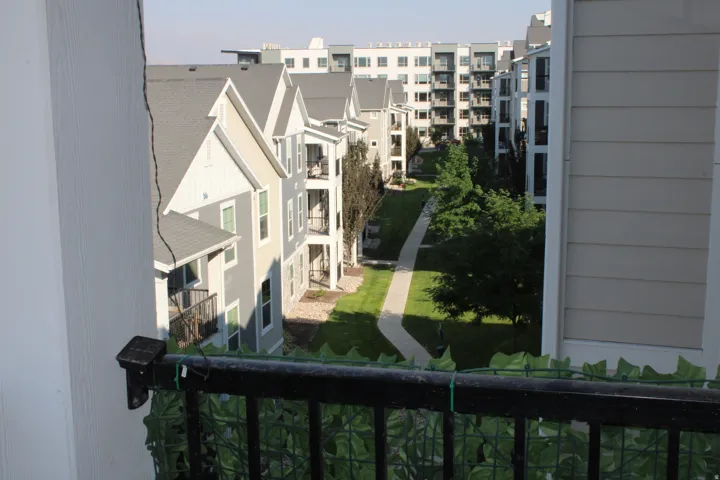 Building exterior with balconies, gray siding, and gabled roofs