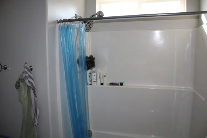 Enclosed shower with a white acrylic tub and surround