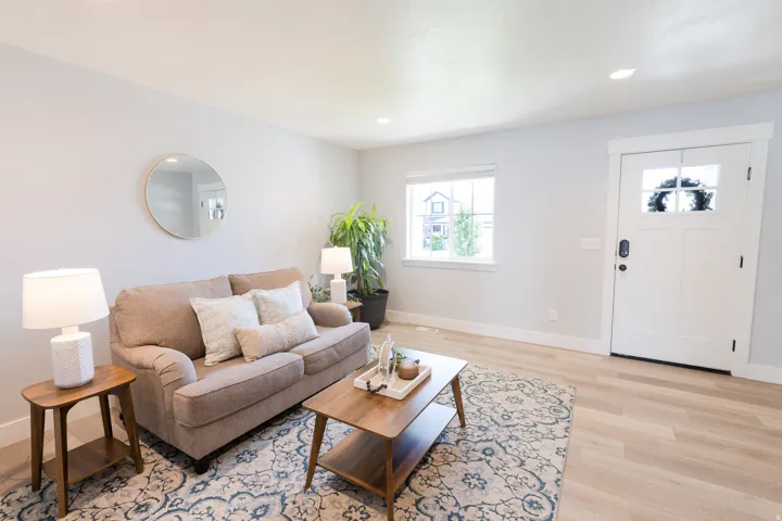 Light wood-finish flooring, white trim, recessed lighting, and a white front door with window panes