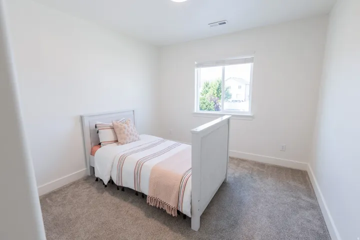 Wall-to-wall carpeting, white walls, and a window with a white frame