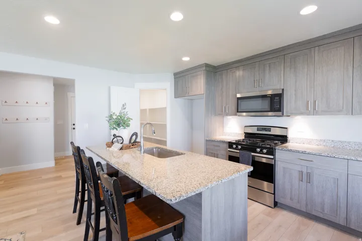Kitchen featuring light wood-finish flooring, recessed lighting, and a kitchen island with a stainless steel sink