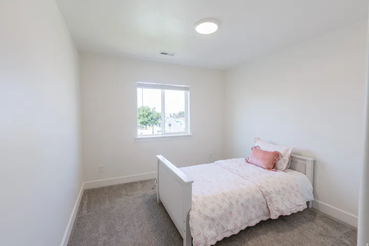 Wall-to-wall carpeting, recessed ceiling lighting, and a window with blinds provide a comfortable atmosphere