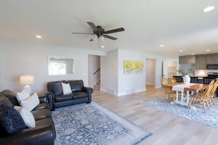 Open-concept living space featuring wood-finish flooring, recessed lighting, and a ceiling fan