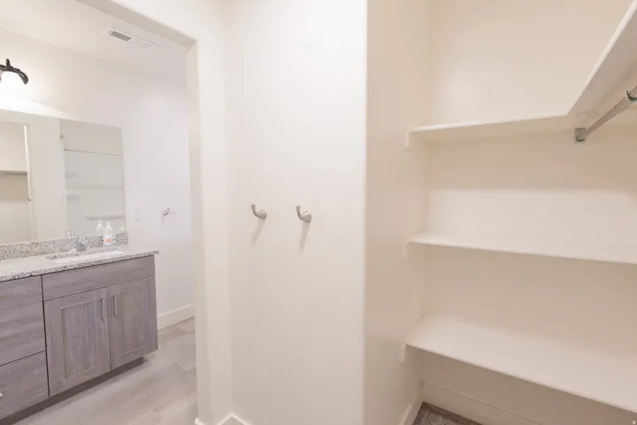 Vanity with a granite countertop, undermount sink, and wood-finish cabinetry