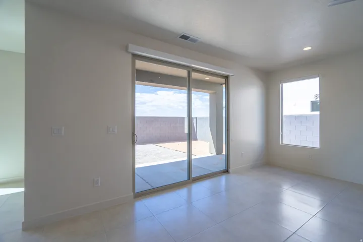 Spacious room featuring large format tile flooring, a window with white trim, and recessed ceiling lighting