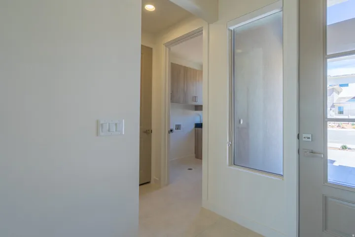 Interior entry with light-toned wall finishes and recessed lighting