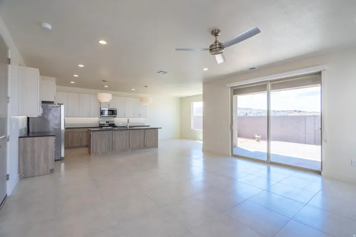 Open-concept living space with large format tile flooring, a contemporary kitchen, and sliding glass door access to the outdoor patio