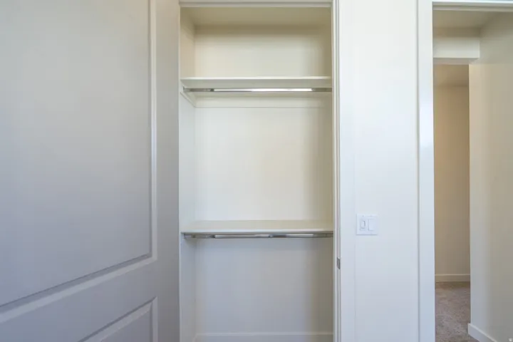 Built-in closet featuring upper and lower shelving, and dual hanging rods