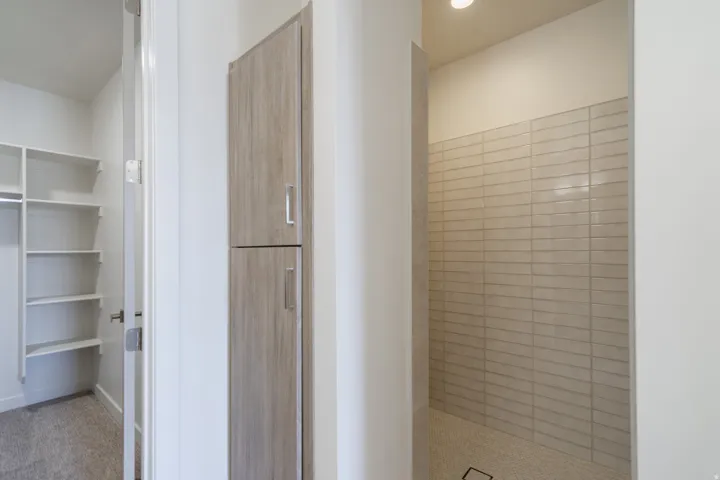 Shower area featuring light-toned subway tile walls and a hexagonal tile floor