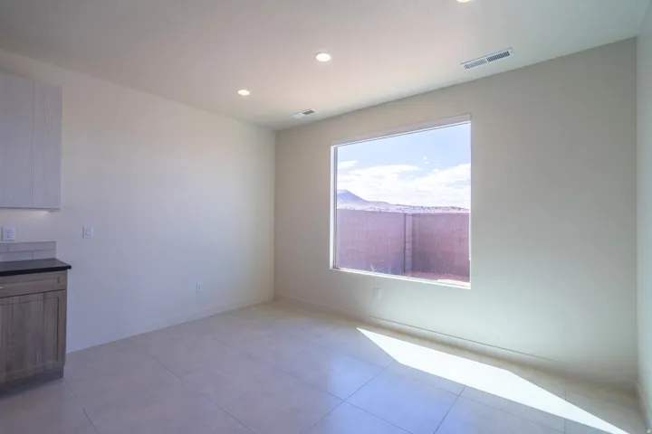 Spacious interior featuring neutral wall tones, recessed lighting, and large format tile flooring