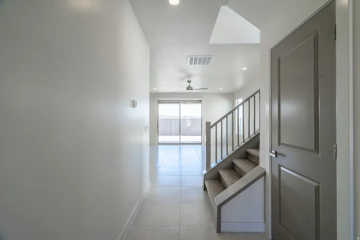 Tile flooring extending through an open hall toward a bright living area