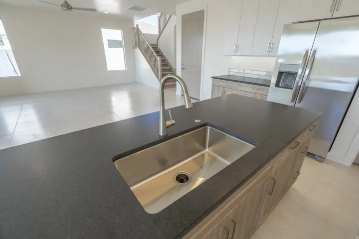 Kitchen island featuring a stainless steel undermount sink and a brushed nickel faucet