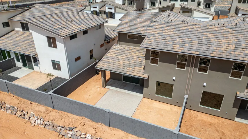 Rear exterior featuring stucco finish, multi-toned tile roofing, private patio, and enclosed yard space