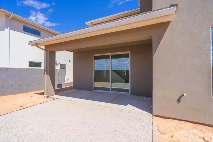 Covered patio area featuring a concrete slab and sliding glass doors