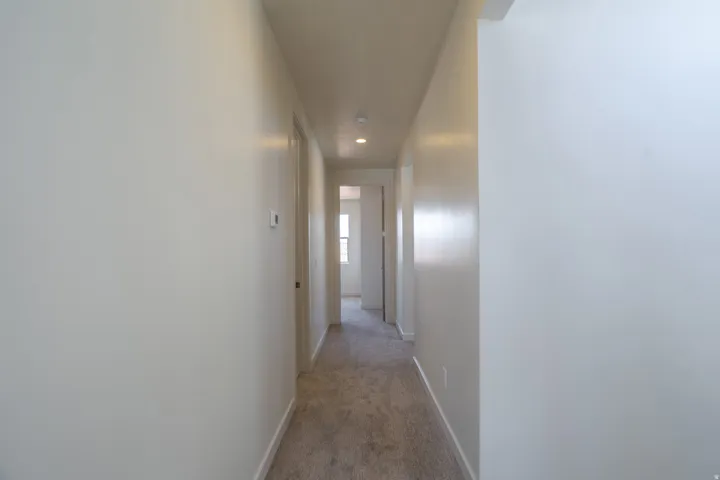Hallway featuring neutral-toned walls, recessed lighting, and carpet flooring