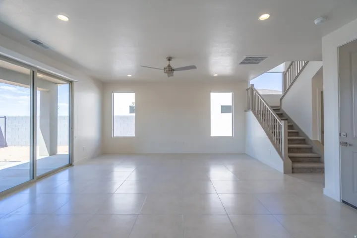Spacious open-concept living area featuring large format tile flooring, a ceiling fan, and recessed lighting