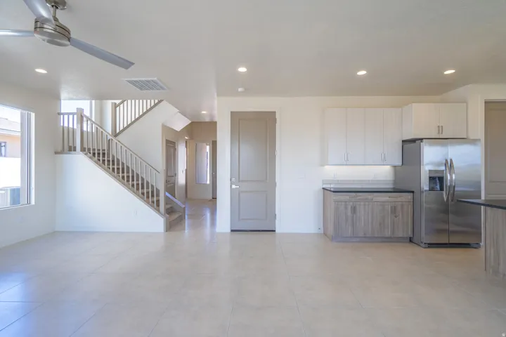 Open-concept living space featuring light-toned tile flooring, recessed lighting, and a modern ceiling fan