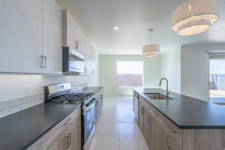 Modern kitchen featuring a gas range, built-in microwave, and stainless steel appliances