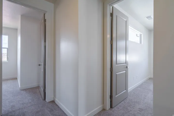 Bright interior spaces featuring light gray carpeting and white baseboards