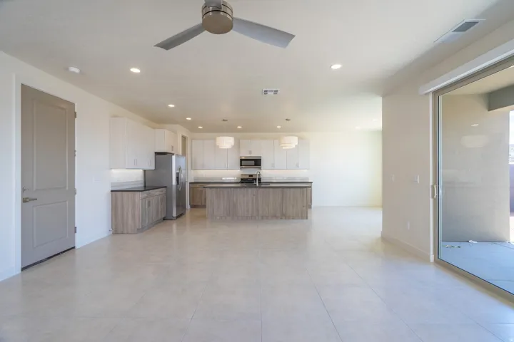 Open-concept living space featuring light-toned tile flooring and a contemporary kitchen