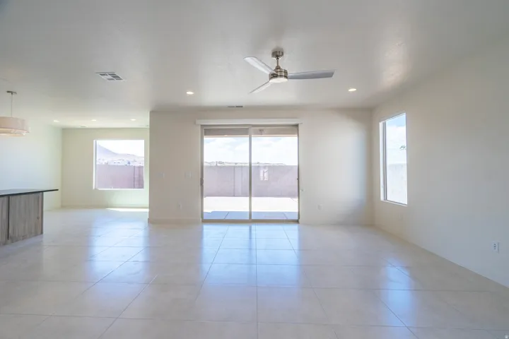 Spacious living area featuring large format tile flooring, recessed lighting, and a modern ceiling fan