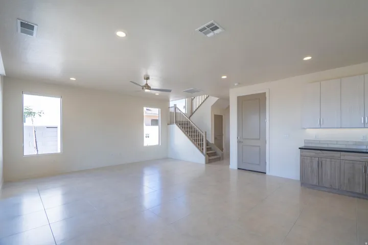 Spacious living area featuring large format tile flooring, recessed lighting, and a modern ceiling fan