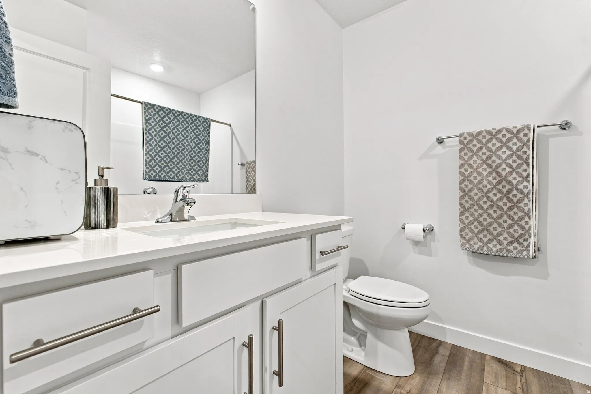 White vanity with a single basin sink, chrome faucet, and integrated countertop