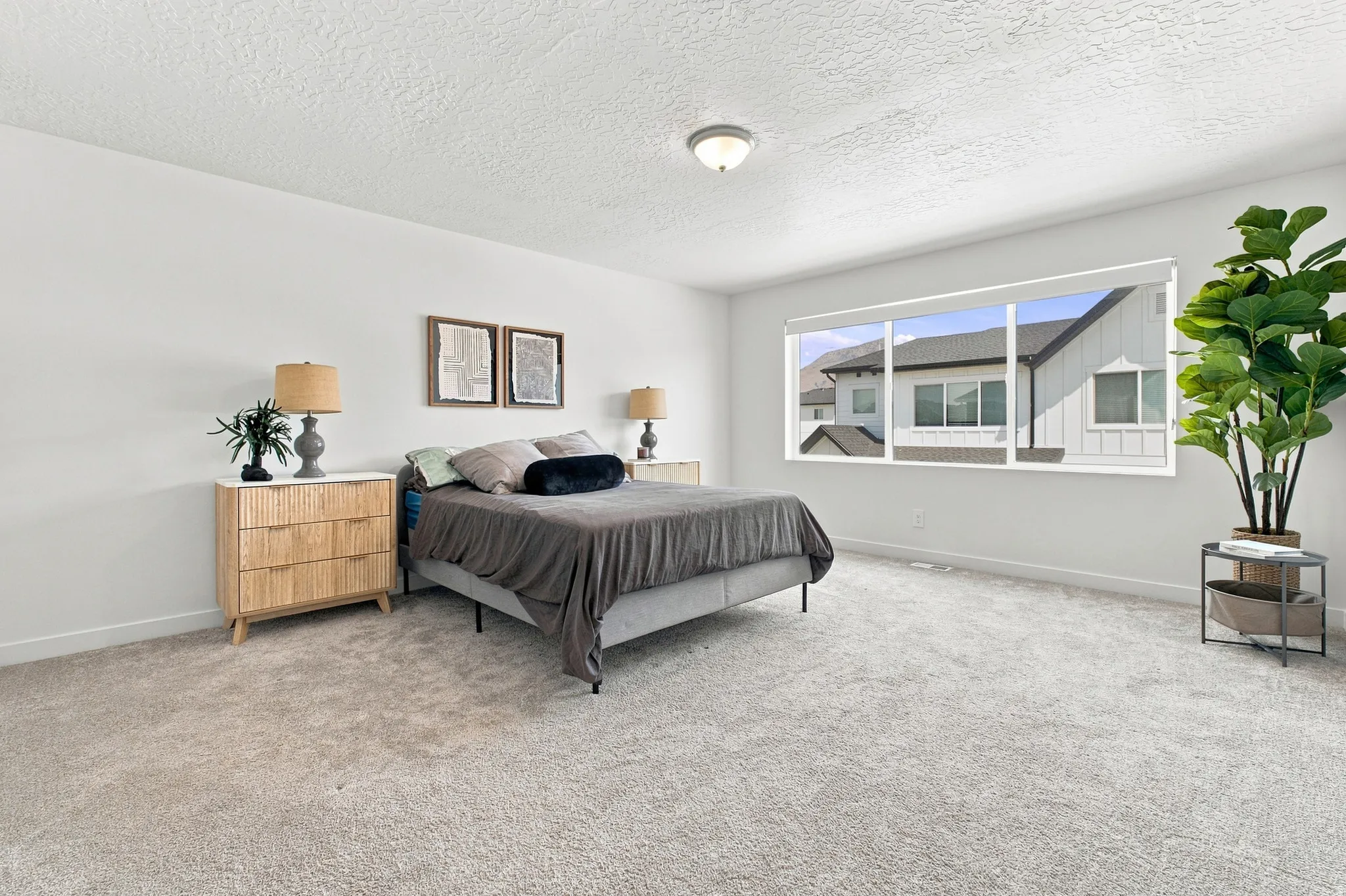 Spacious room featuring light-colored carpeting, white wall finishes, and a large multi-pane window