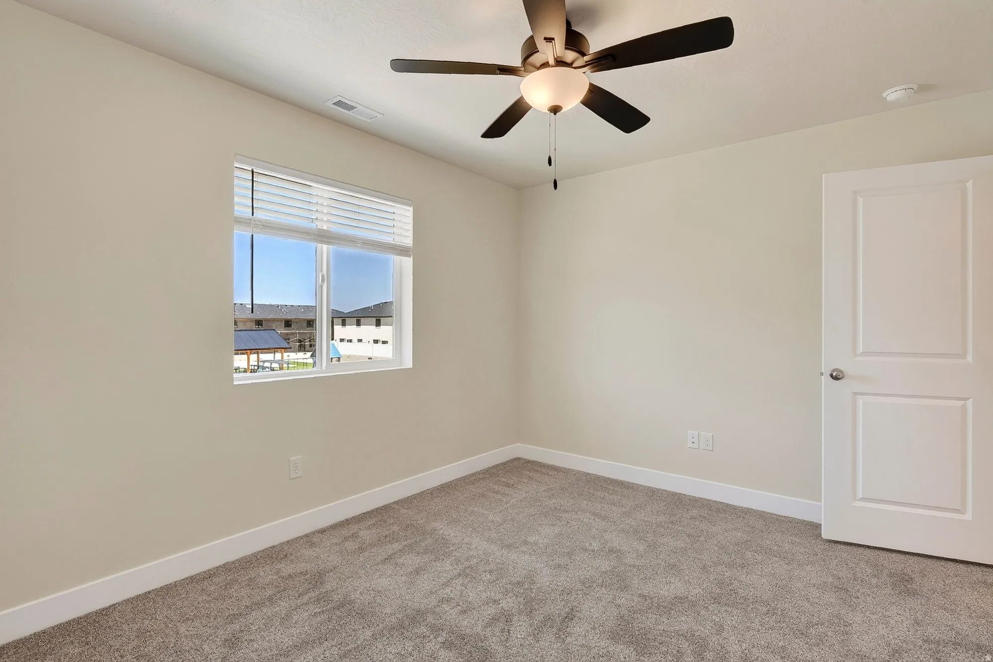 Neutral toned walls, contemporary ceiling fan with integrated lighting, window with blinds, and paneled door