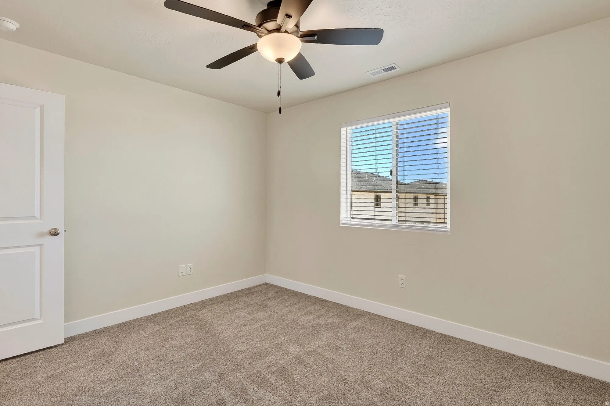 Neutral wall finishes, recessed window, ceiling fan with integrated lighting, and carpet flooring