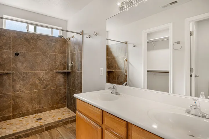 Walk-in shower with large format tile, dual shower heads, and built-in shelving