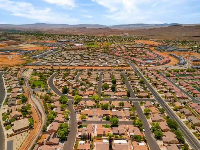 Expansive residential development featuring numerous single-story homes, paved streets, and mature trees