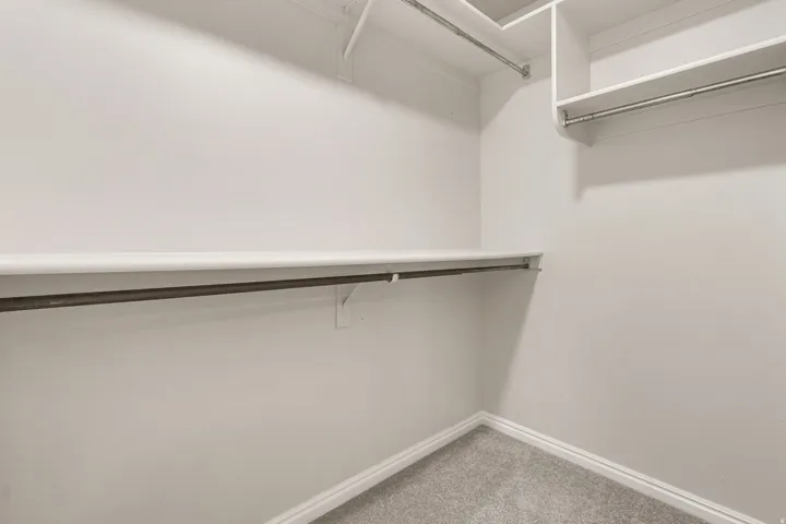 Recessed shelving, multiple hanging rods, and light gray carpeting
